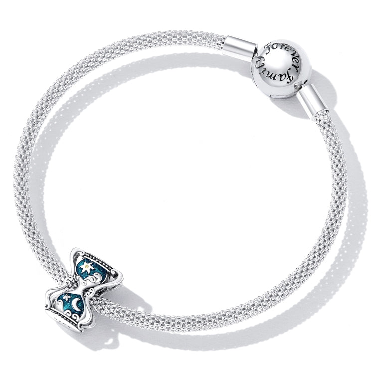 Silver mesh chain bracelet with sun and moon hourglass charm near clasp