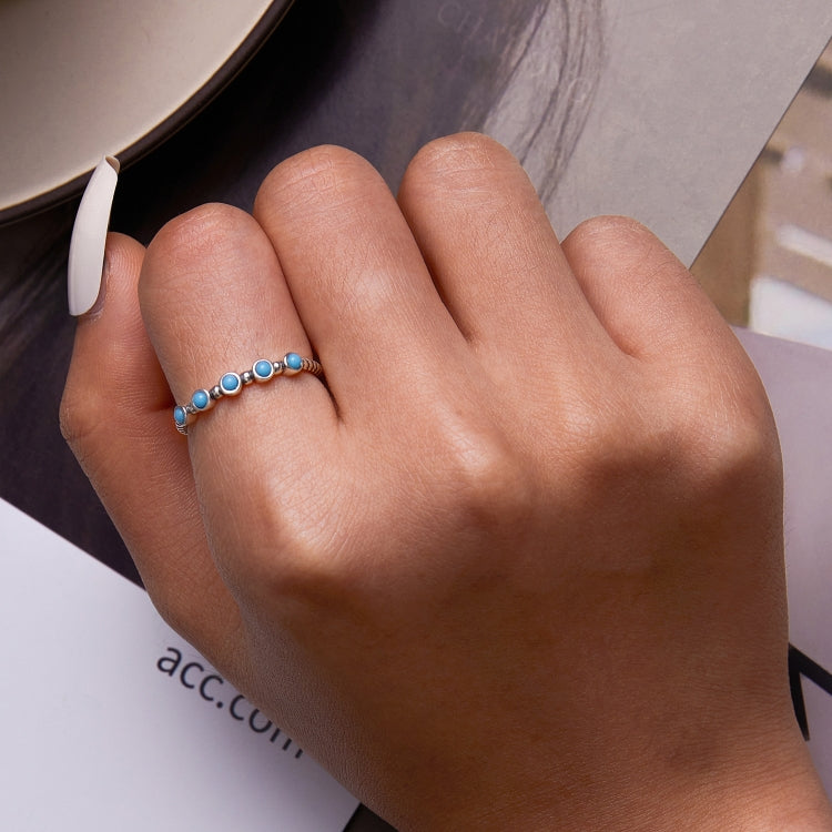 Small turquoise bead open ring on silver band, worn on finger