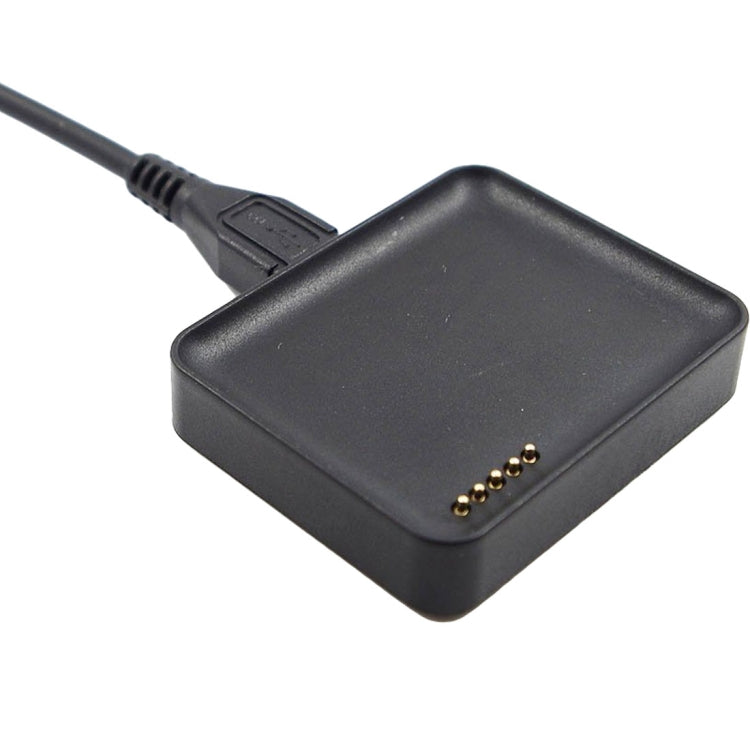Black watch charging base with gold pin contacts and attached charging cable.