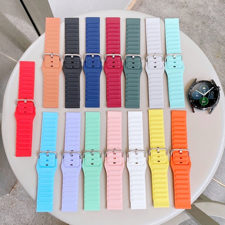 Colorful silicone watch bands with ridged straps and metal pin buckles on display tray.