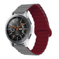 Smart watch with dark red silicone band and metal clasp, round black dial with orange details