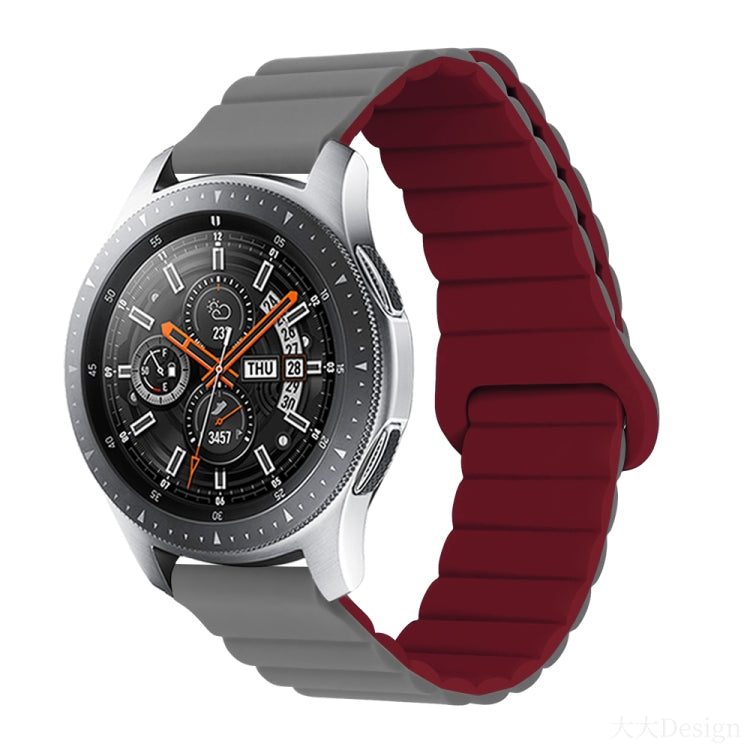 Smart watch with dark red silicone band and metal clasp, round black dial with orange details
