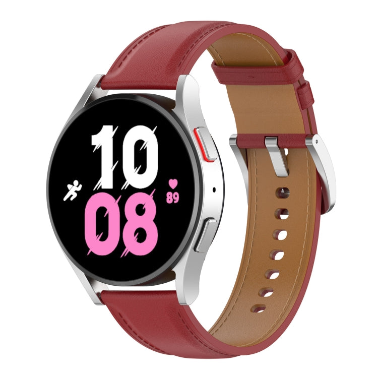 Red leather watch band with metal clasp and punched holes, worn on a watch.