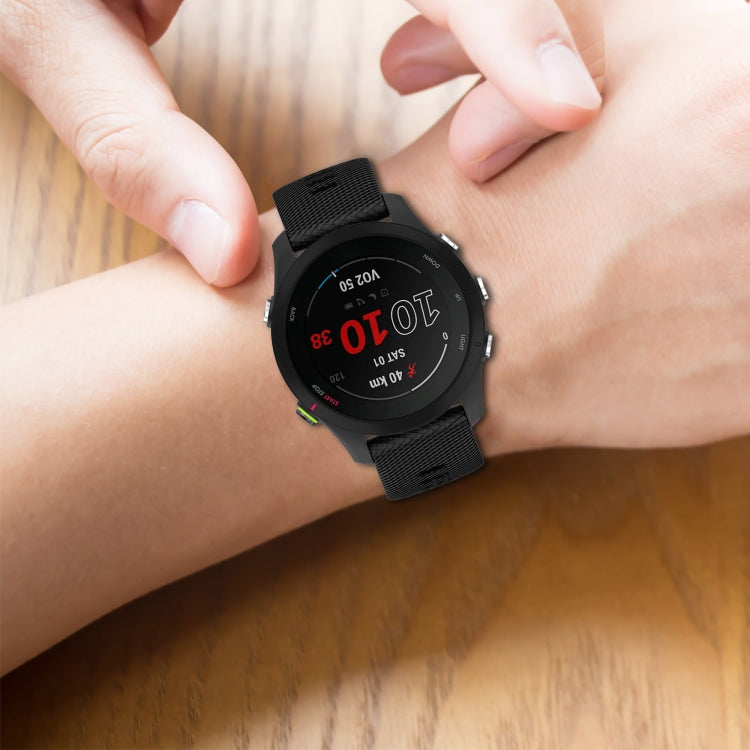 Black 22mm textured silicone watch band on wrist, adjustable clasp and strap holes