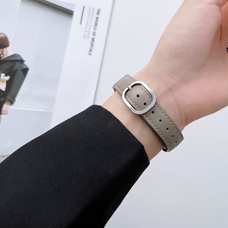 Beige genuine leather watch band with round silver buckle on a hand