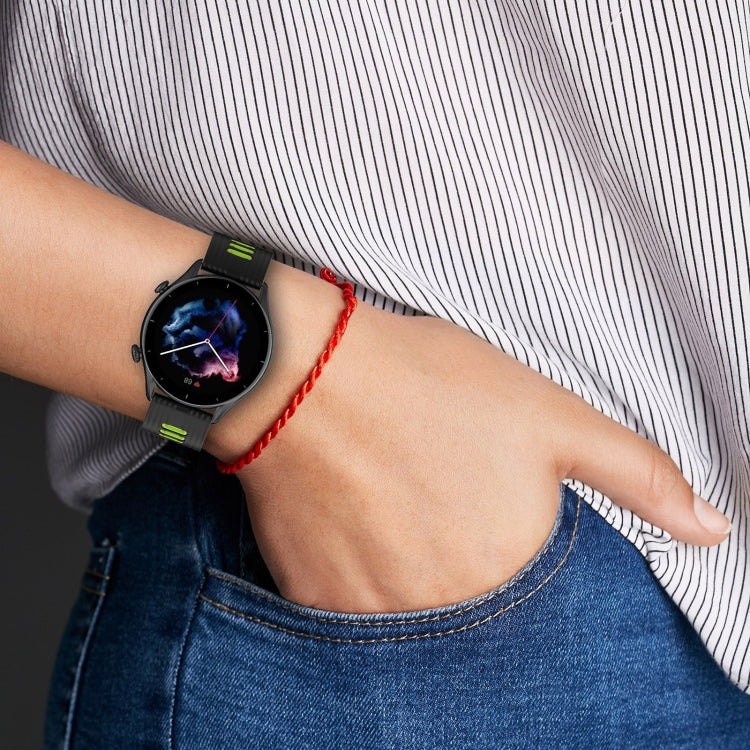 Silicone watch band on wrist in black with neon green accents and clasp.