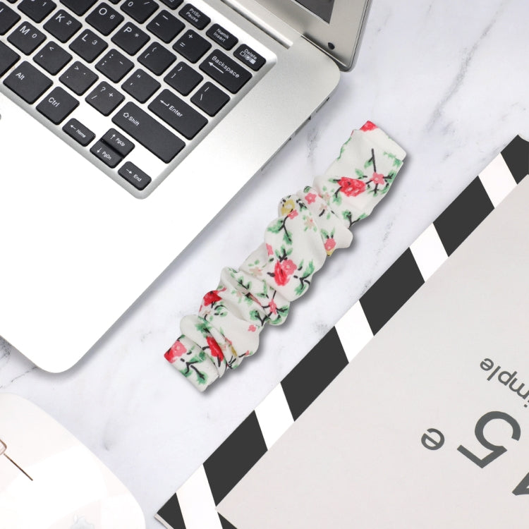 Floral cloth watch band, white with red flowers and green leaves; laid flat for view.
