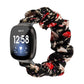 Black floral cloth watch band with red blossoms and cream leaves; smartwatch shown.