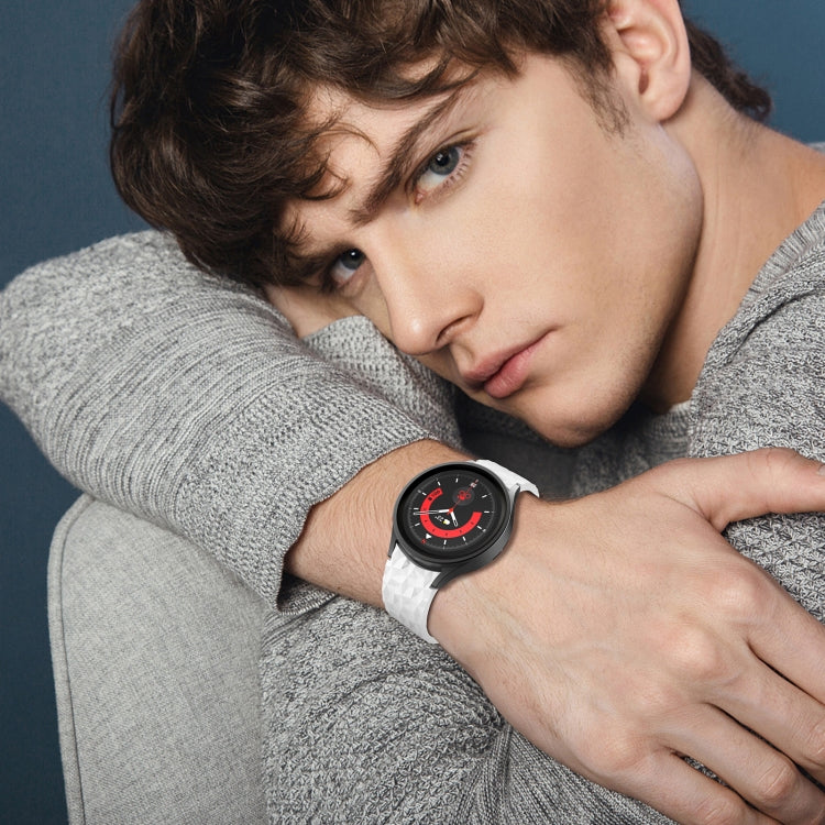 Grey knit sleeve with dark watch and rhombus-texture silicone band on wrist.