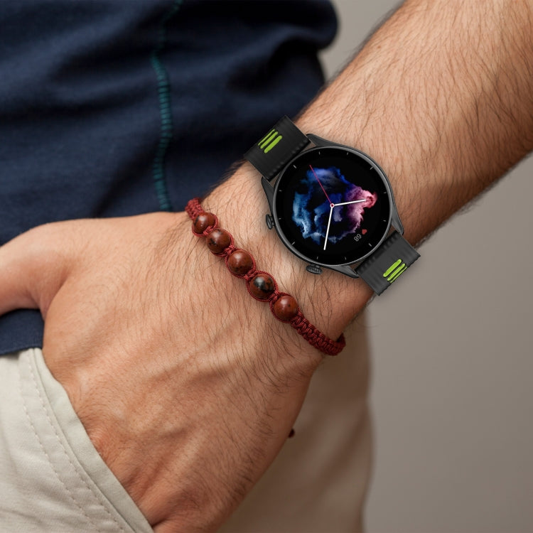 Black silicone watch band with green accents and metal buckle, worn on wrist
