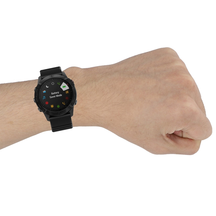 Quick-release watch wrist strap with plastic buckle, black silicone band with texture.