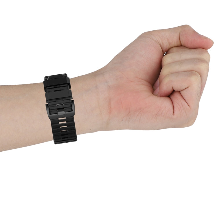 Black quick-release watch strap worn on wrist with plastic buckle clasp
