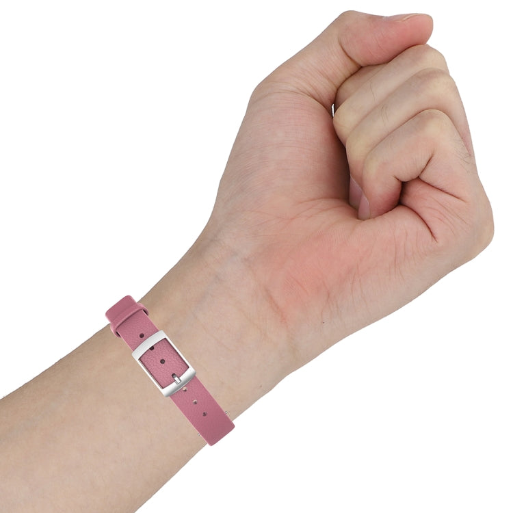 Pink leather watch strap on hand with silver buckle and punched holes