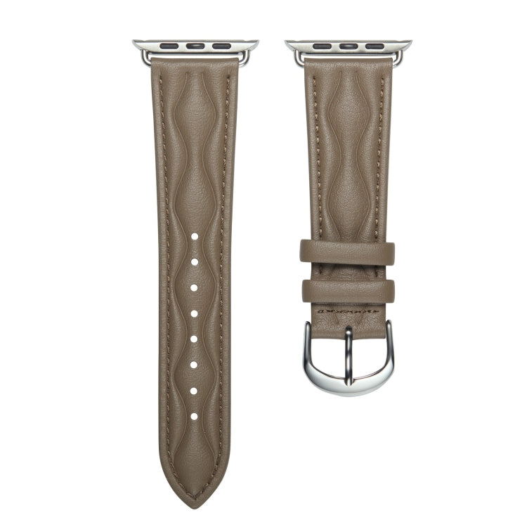 Taupe leather Apple Watch strap with metal buckle and punched strap holes.