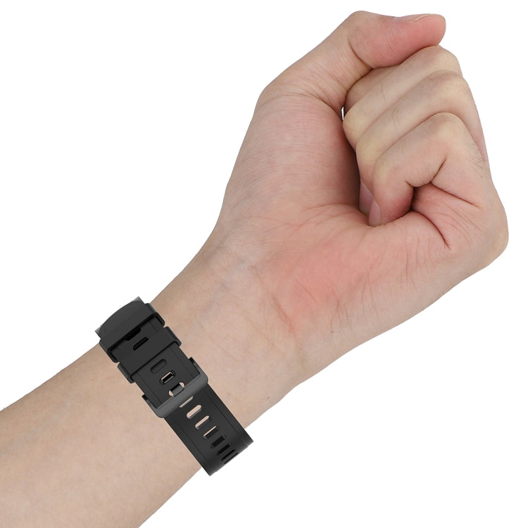 Black silicone watch strap on a hand, showing pin buckle and clasp