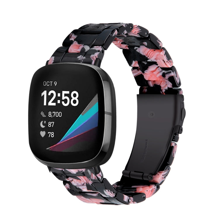 Black resin smartwatch band with pink floral pattern and chunky links for Fitbit Versa