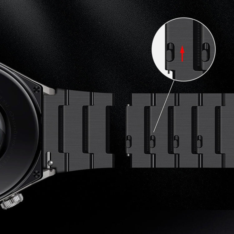 Quick-release pin detail on dark metal watch band with linked segments