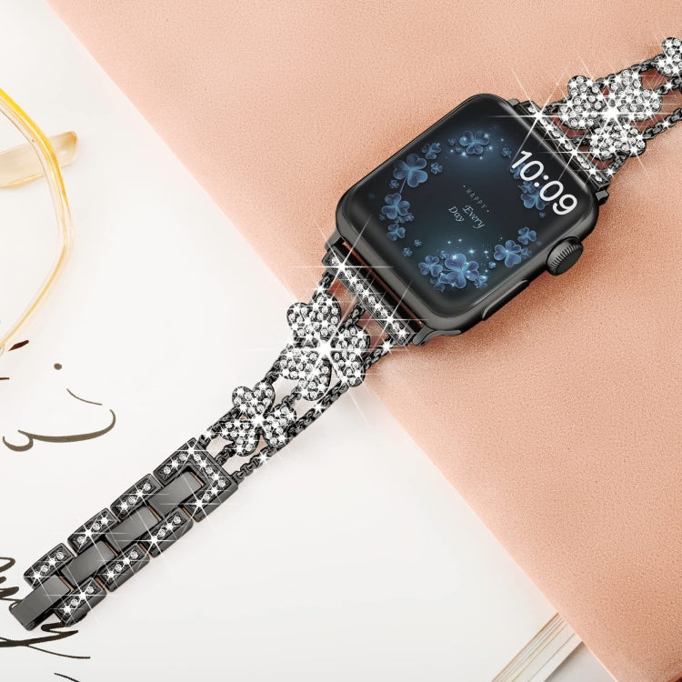 3-leaf clover diamond watch band worn on wrist, black links with silver rhinestone charms