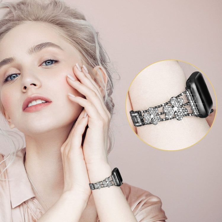 3-leaf clover diamond watch band on wrist, black links with sparkling silver clover charms