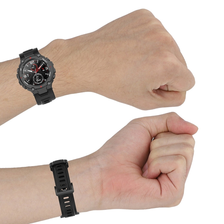 Black silicone watch strap on wrist with multiple rows of adjustment holes