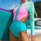 Color-block one-piece bikini with long sleeves, pink and teal panels, front zipper.