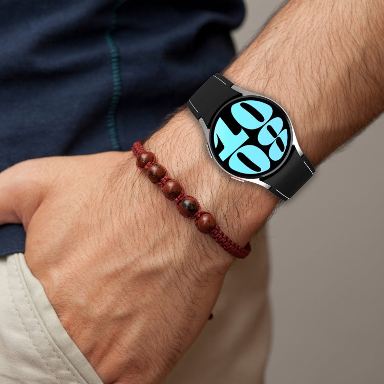 Leather silicone watch band on wrist in black with metal buckle and perforated strap