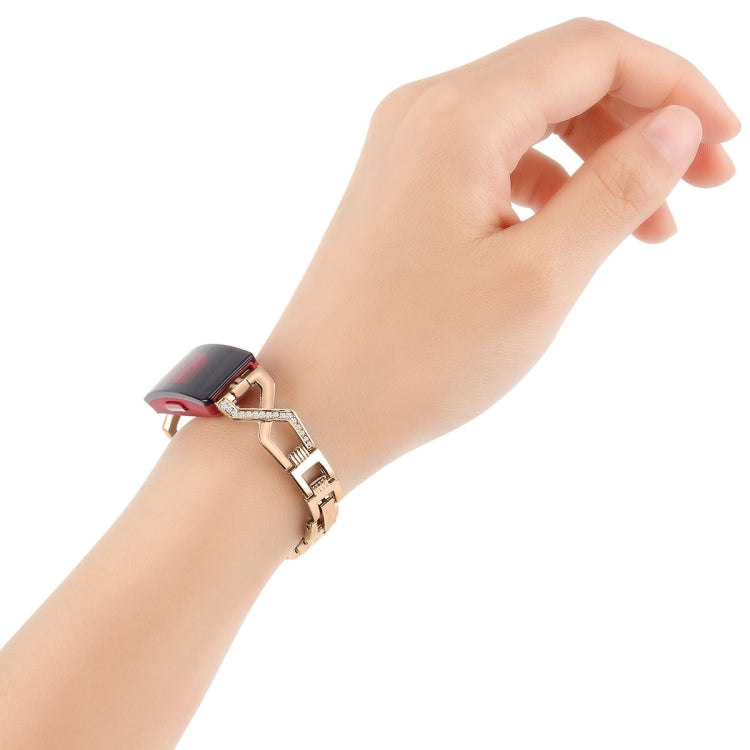 Rose gold metal watch band on wrist with black smartwatch and rhinestone link accents
