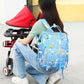 Blue cartoon baby care backpack with multiple front pockets, worn on a stroller