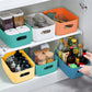 Plastic storage baskets with cutout handles organizing items in a cabinet shelf