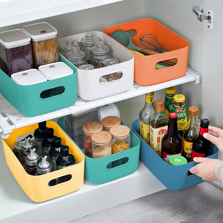 Plastic storage baskets with cutout handles organizing items in a cabinet shelf