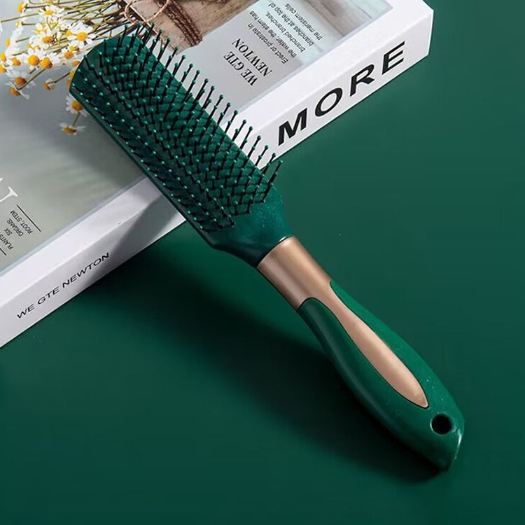 Teal hair massage brush with black bristles on cushion pad and curved handle