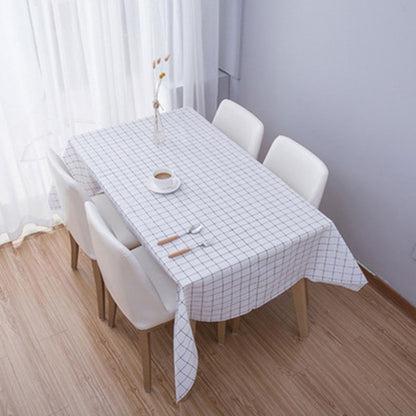 Grey plaid PVC coffee tablecloth with grid pattern, draped over a dining table