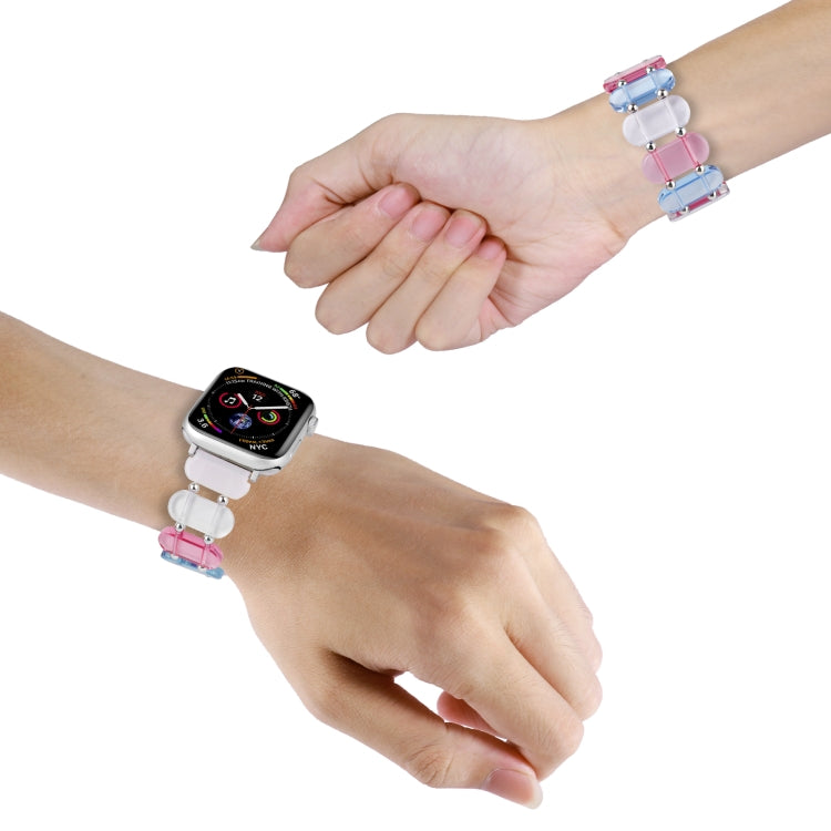 Stretch resin watch band on wrist with pink and light blue transparent links