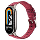 Wine red nylon canvas watch band with metal clasp and pin buckle for a fitness tracker.