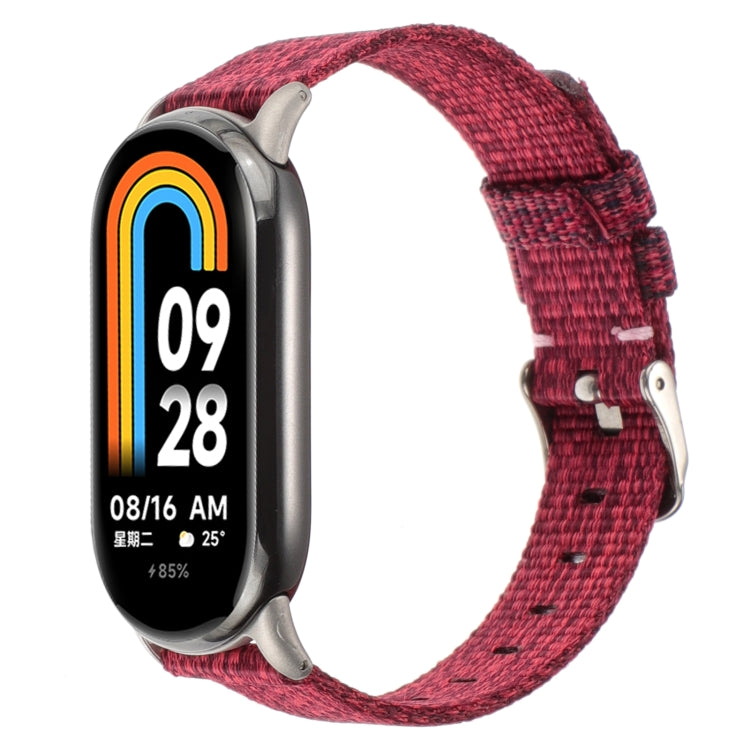 Wine red nylon canvas watch band with metal clasp and pin buckle for a fitness tracker.