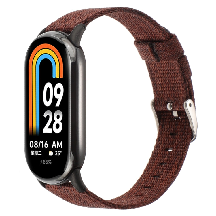 Brown nylon canvas watch band with metal clasp and pin buckle for a fitness tracker.
