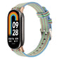 Multicolor striped nylon canvas watch band with metal clasp and pin buckle for a fitness tracker.