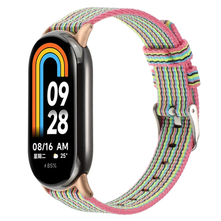 Pink multicolor striped nylon canvas watch band with metal clasp and pin buckle for a fitness tracker.