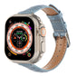 Light blue crocodile leather Apple Watch band with stitched holes and buckle.