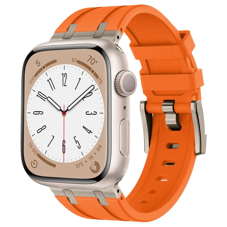 Bright orange silicone Apple Watch band with silver connectors, shown fitted to a watch