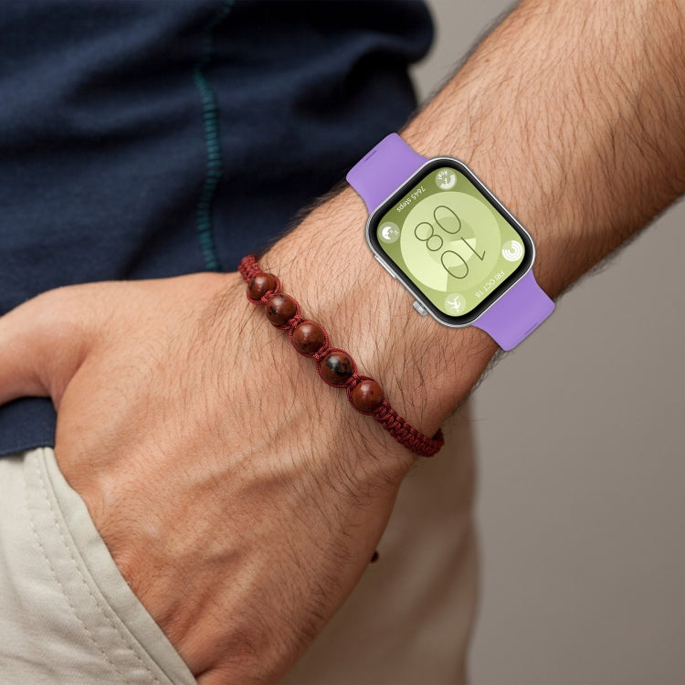 Purple silicone sports watch band worn on a wrist