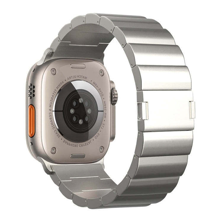 Silver metal watch band with broad links, shown with the watch back and orange side button.