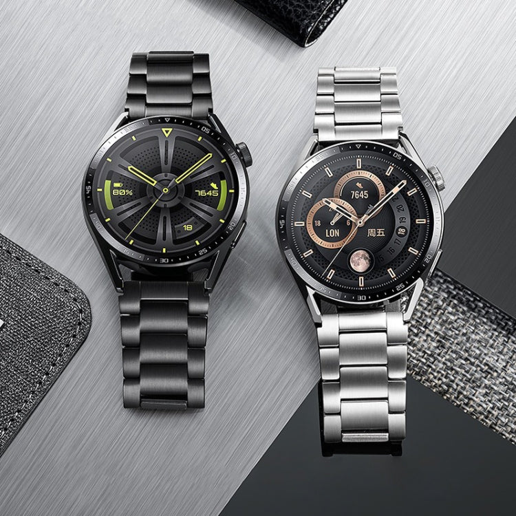 Black and silver metal link watch bands fitted to two smartwatches
