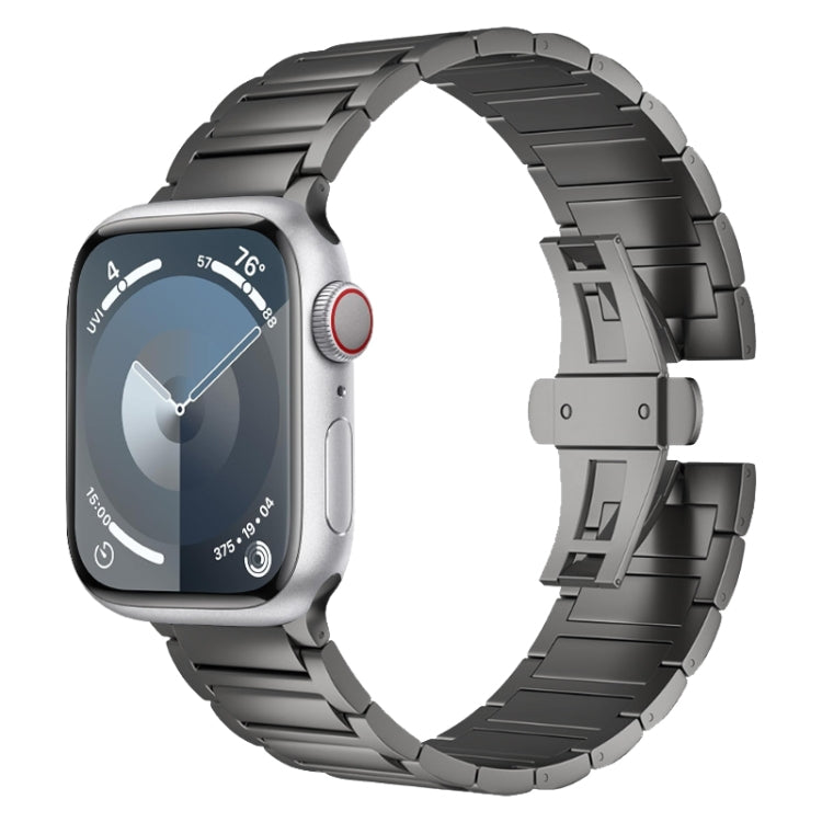 Dark titanium alloy watch band with segmented links and butterfly buckle, shown on a smartwatch