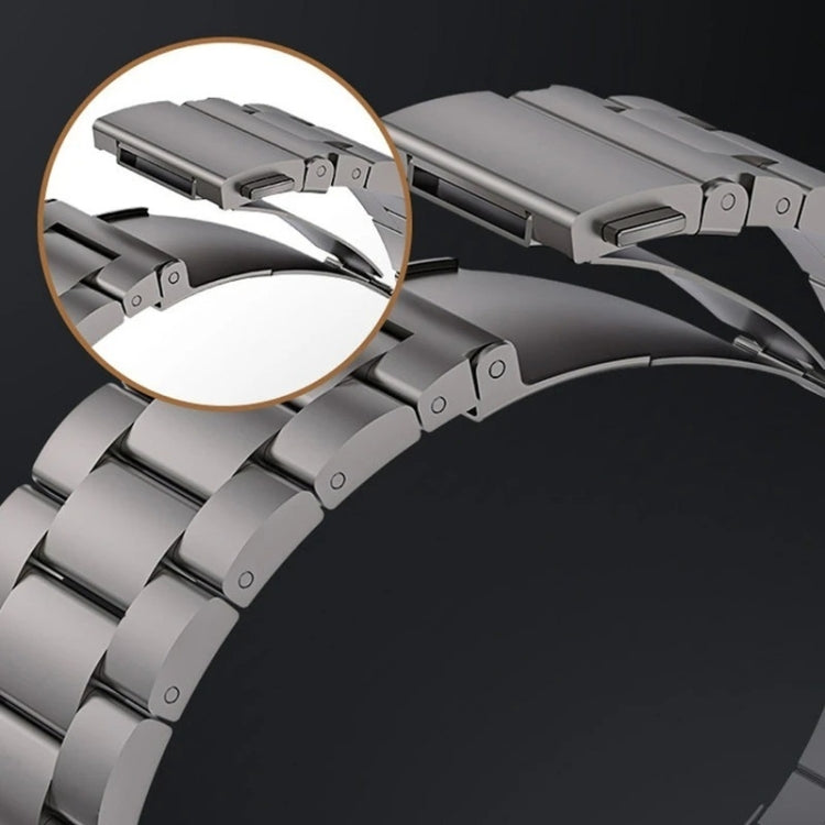 Gray titanium alloy watch band with a flat folding clasp and broad metal links.