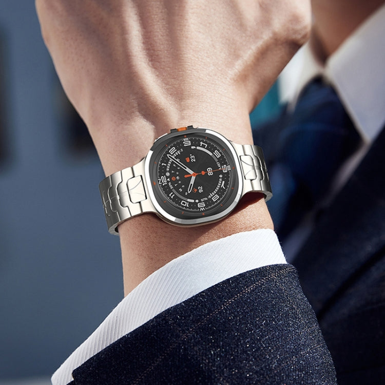 Silver titanium link watch band with a folding clasp, worn with a watch.
