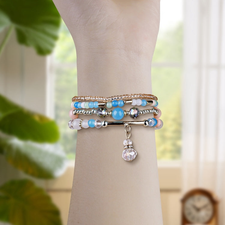 Multicolor beaded Apple Watch band wrapped around wrist with a crystal drop charm