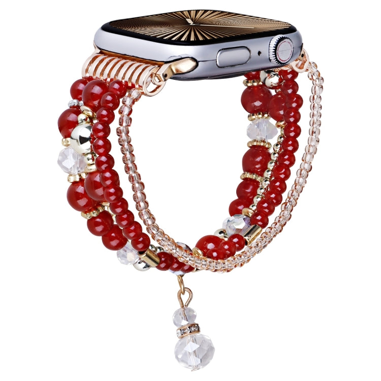 Apple Watch band with red beads, copper-tone chains, and a dangling crystal charm