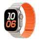 Apple Watch with a starlight and bright orange silicone band