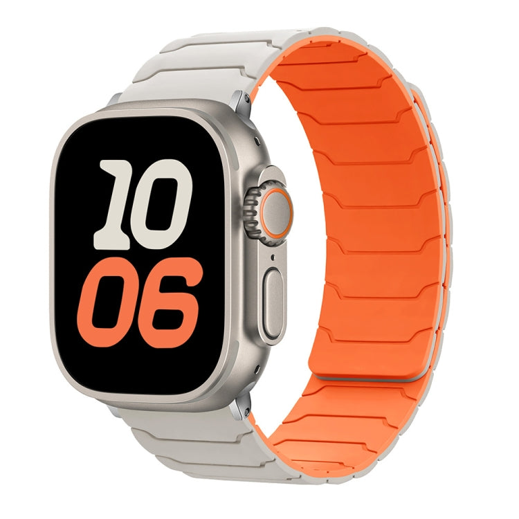 Apple Watch with a starlight and bright orange silicone band